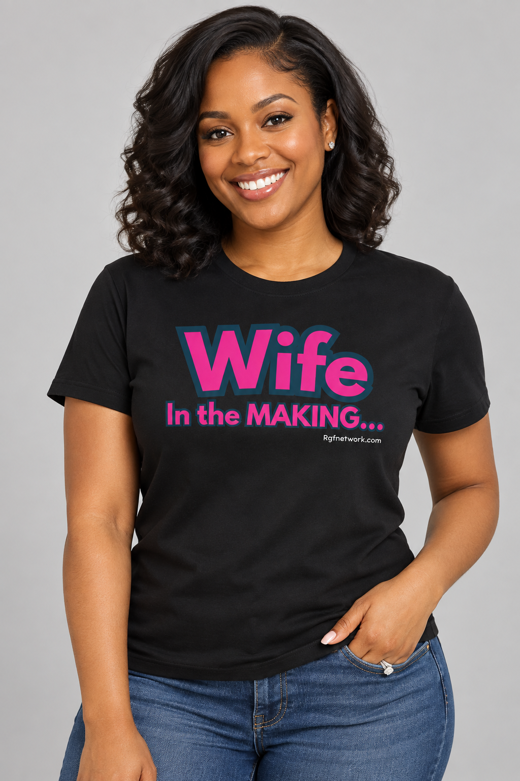 Woman wearing the black Wife in the Making shirt with pink lettering
